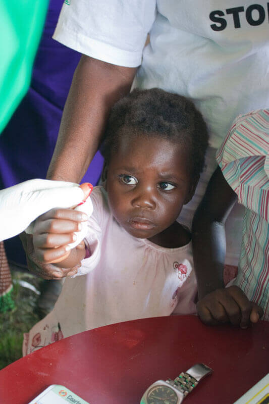 A researcher holds onchocerciasis (river blindness) diagnostic tests. Photo: PATH/Patrick McKern